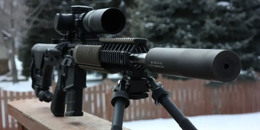 Blacked out AR rifle with silencer and scope
